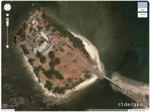 The satellite view shows something like a bridge leading to the island. There is also at least one building on it. 